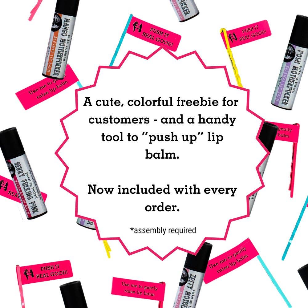 A photo showing colorful bobby pins and "push it real good" flags that are shipped with each tube of lip balm for dispensing the balm. The tubes are plastic free and compostable so a pin is included to push the tube up. Remember push pops?? Same idea.