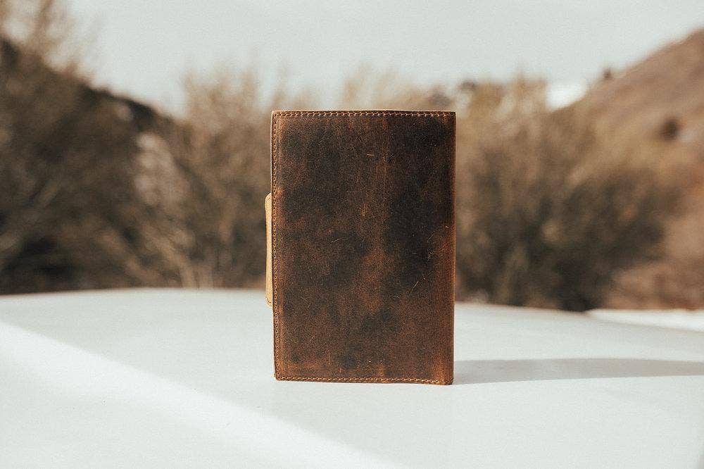 A photo showing the back side of a leather journal outdoors.