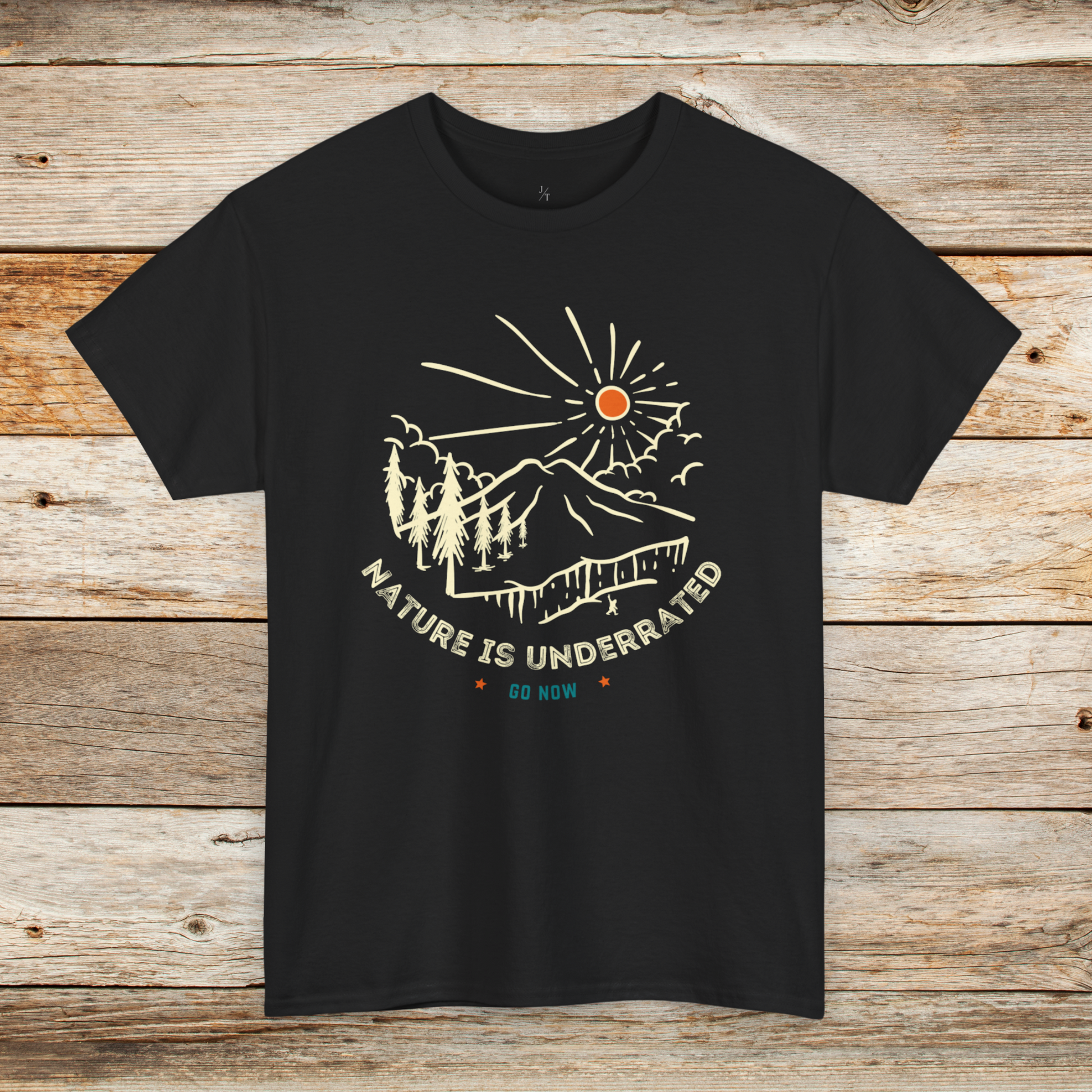 A black tee shirt with Nature is Underrated graphic with mountains, trees and sunshine.